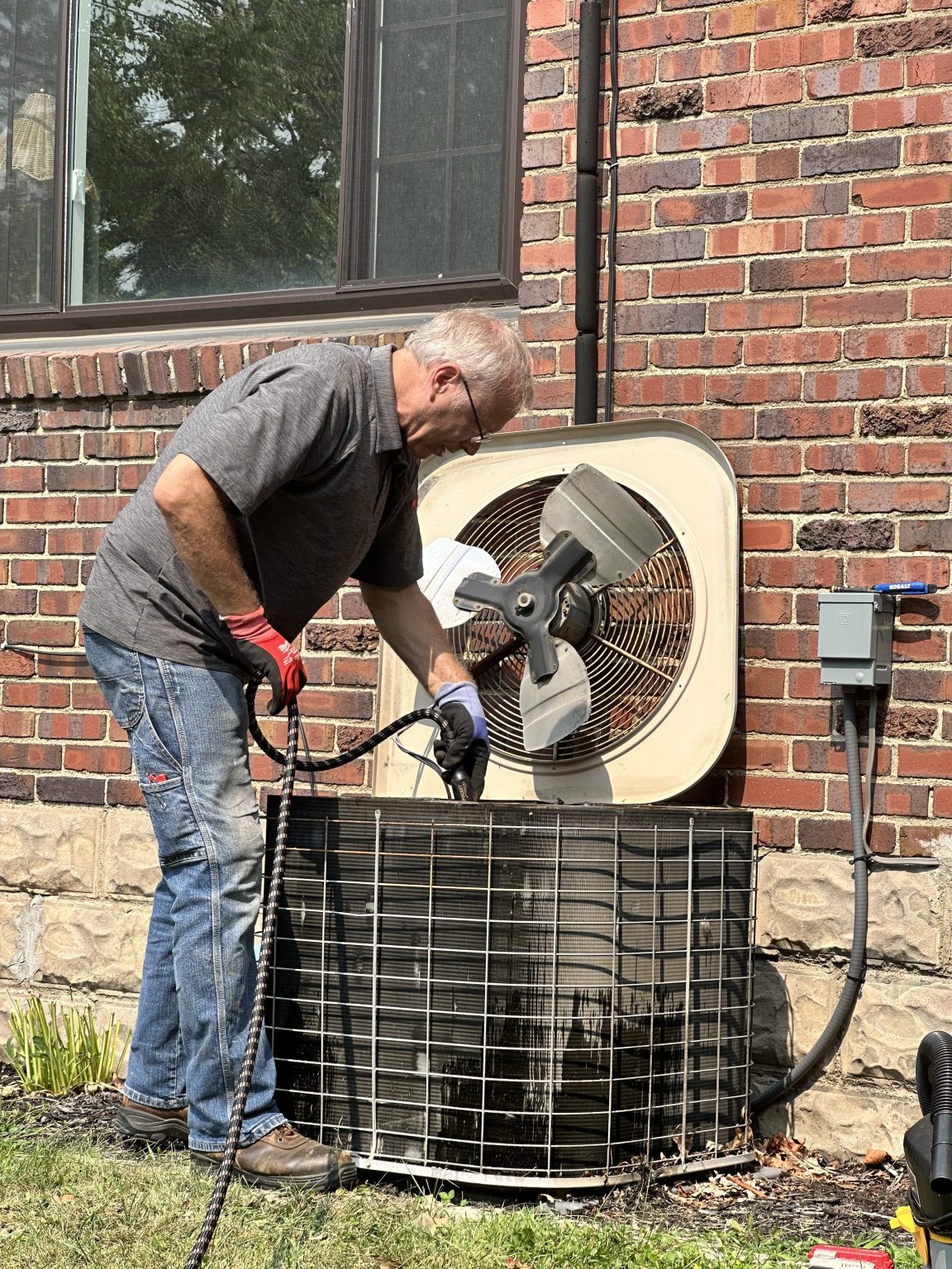 Homelio technician cleaning a condenser coil